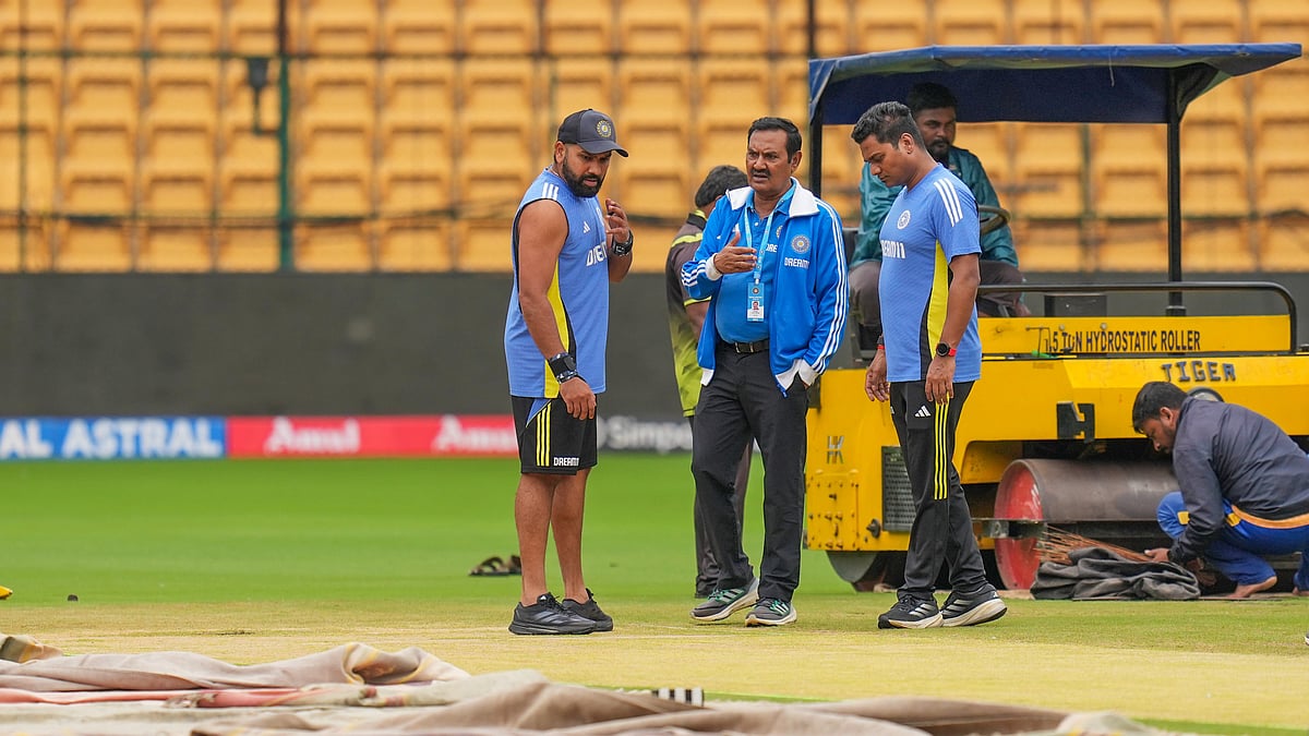  India's captain Rohit Sharma inspects the pitch after rain stopped play during the first day of the first test cricket match between India and New Zealand, at M Chinnaswamy Stadium in Bengaluru. - PTI Photo/Shailendra Bhojak