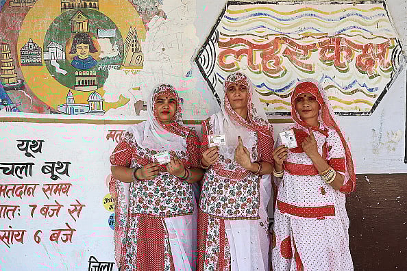 Women display their fingers marked with indelible ink after voting in Lok Sabha polls in Rajasthan