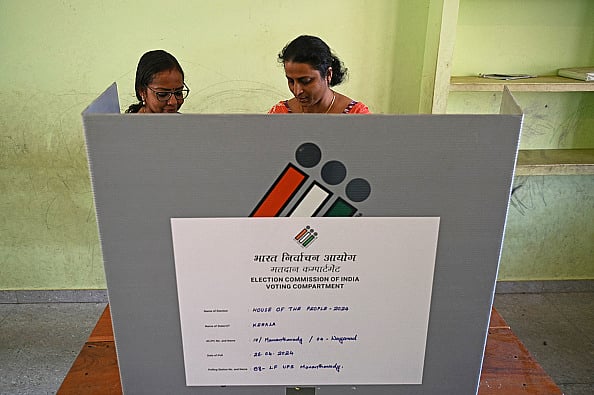Officials work on an EVM at a polling station in Wayanad district of Kerala, April 25