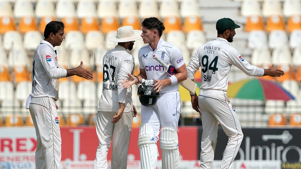 AP Photo/K.M. Chaudary : Pakistan's Noman Ali, left, shakes hand with England's Matthew Potts, centre, after winning the second test cricket match against England, in Multan.