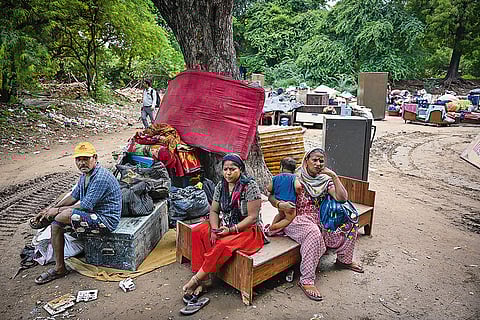 People with their belongings on the road after their houses were demolished