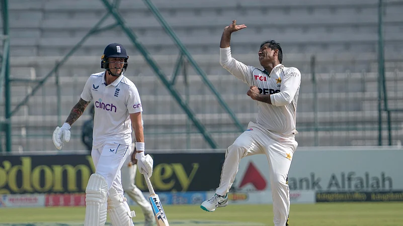 Pakistans Noman Ali, right, bowls as Englands Brydon Carse watches. AP Photo
