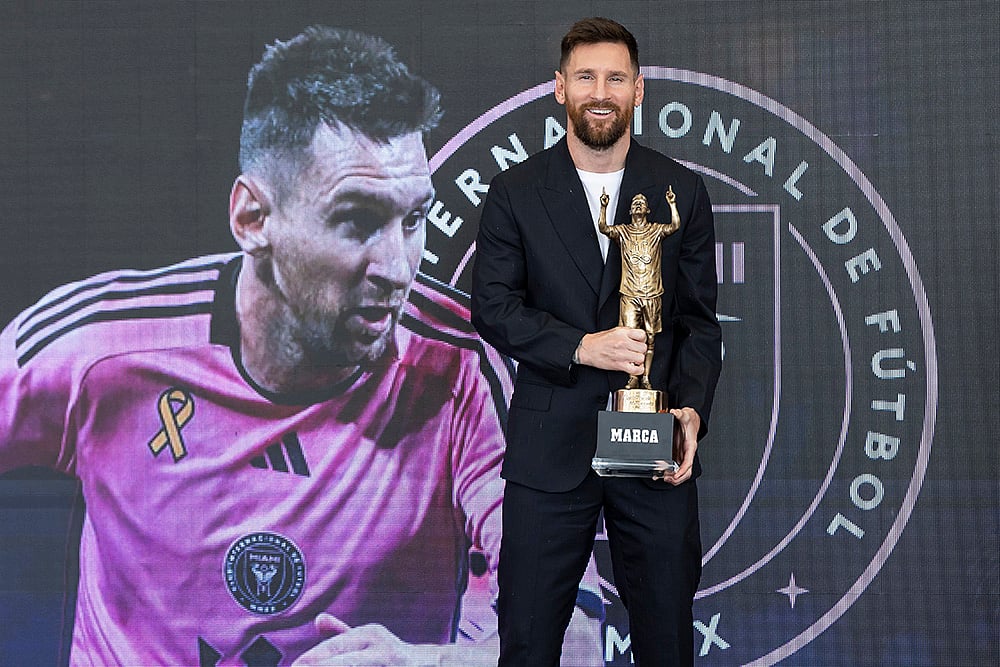 | Photo: Matias J. Ocner/Miami Herald via AP : Lionel Messi holds the MARCA America Award