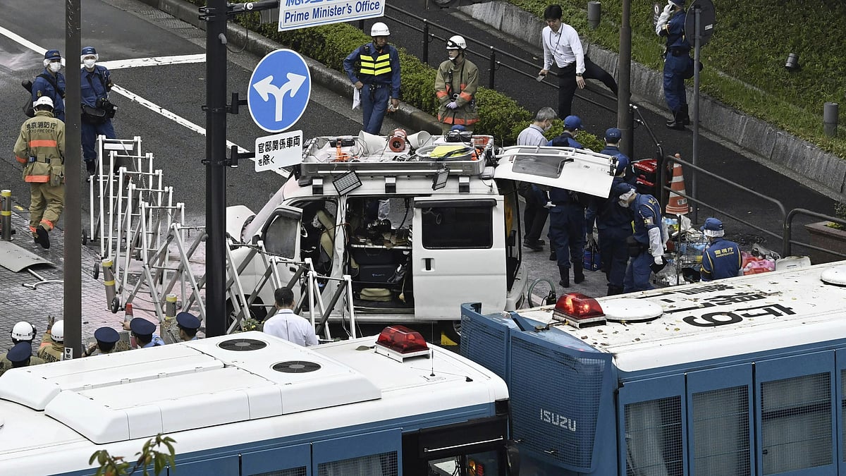 AP : Officials work near a vehicle, center, which was stuck against a barricade near the prime minister's office in Tokyo.