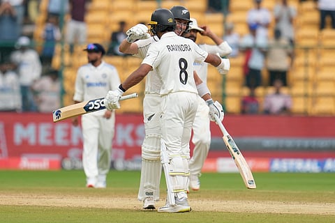 New Zealand's Will Young and Rachin Ravindra celebrate after their win against India in Bengaluru.