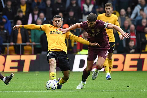 EPL 2024-25: Wanderers' Joao Gomes, left, and Manchester City's Ruben Dias vie for the ball