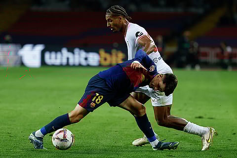 La Liga 2024-25: Barcelona's Pau Victor, front, duels for the ball with Sevilla's Loic Bade