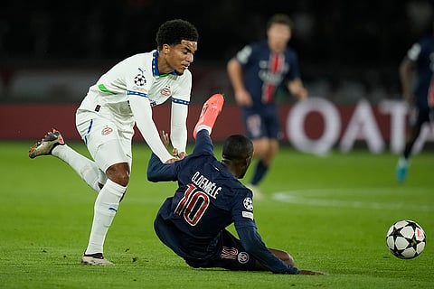 Champions League 2024-25: PSV's Malik Tillman, left, pushes PSG's Ousmane Dembele