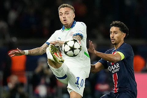 Champions League 2024-25: PSV's Noa Lang, left, kicks the ball chased by by PSG's Marquinhos