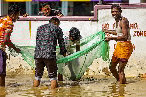 Karnataka Rains: People catch fish in a waterlogged area