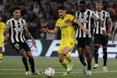 Copa Libertadores, SF 1st Leg: Rodrigo Perez of Uruguay's Penarol, center, fights for the ball with Bartolomeu Jacinto of Brazil's Botafogo