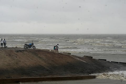 Cyclone ‘Dana’: Visitors watch as waves crash ashore at a beach