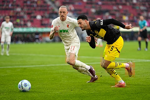 Bundesliga soccer: Dortmund's Ramy Bensebaini, right, and Augsburg's Marius Wolf