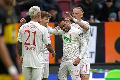 Bundesliga soccer: Augsburg's Alexis Claude-Maurice, centre, celebrates with teammates after scoring his side's opening goal