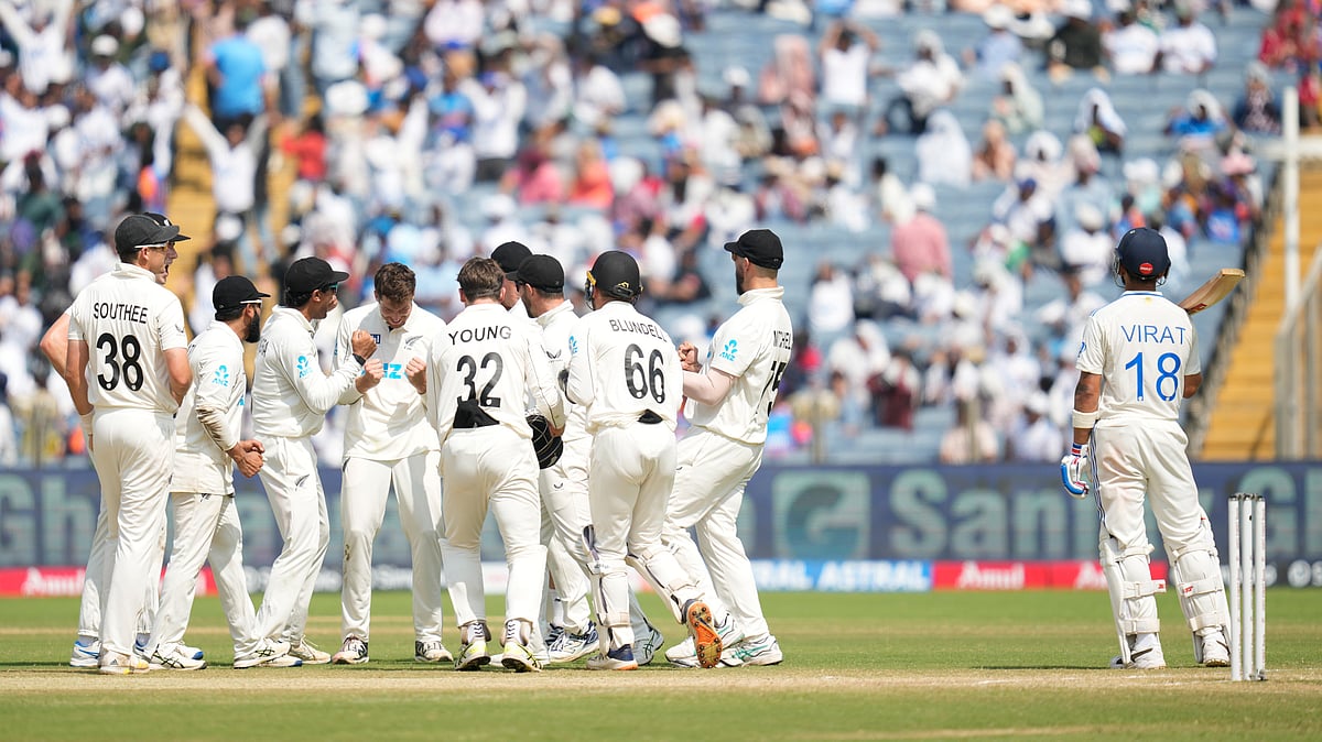 New Zealand' players celebrates the dismissal of India's Virat Kohli , right, during the day three of the second cricket test match between India and New Zealand at the Maharashtra Cricket Association Stadium , in Pune, India, Saturday, Oct. 26, 2024.  - (AP Photo/Rafiq Maqbool)