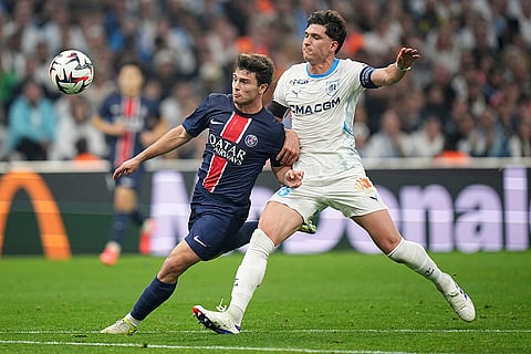 Ligue 1 Soccer 2024-25: PSG's Joao Neves, left, and Marseille's Leonardo Balerdi fight for the ball