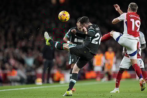 Premier League 2024-25: Liverpool's Andrew Robertson, centre, kicks the ball ahead of Arsenal's Leandro Trossard