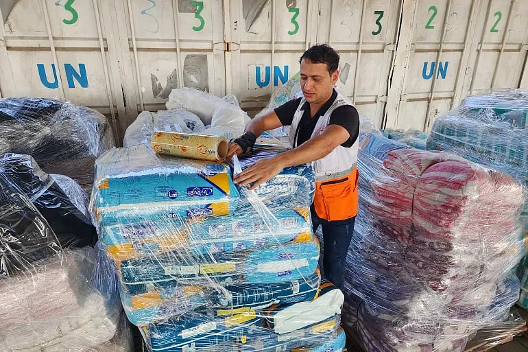 AP : UN workers prepare aid for distribution at UNRWA warehouse in Gaza Strip