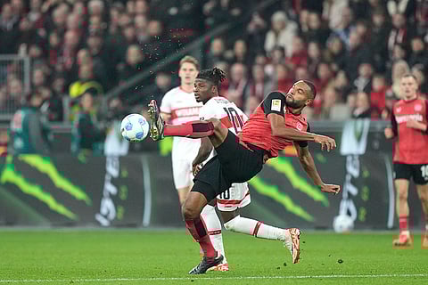 Bundesliga soccer 2024-25: Leverkusen's Jonathan Tah, centre, kicks the ball ahead of Stuttgart's El Bilal Toure