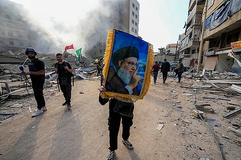 A woman holds a picture of Hassan Nasrallah
