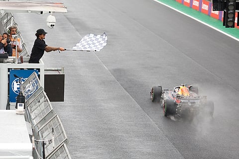 Brazilian Grand Prix 2024: Max Verstappen takes the chequered flag waved by Brazilian surfer Gabriel Medina