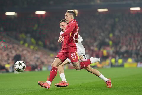 Champions League 2024-25: Leverkusen's Florian Wirtz, rear, chases Liverpool's Kostas Tsimikas who plays minus one of his boots