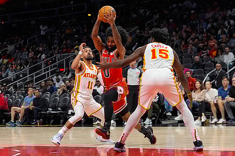 NBA: Bulls guard Coby White (0) goes between Hawks guard Trae Young (11) and Clint Capela