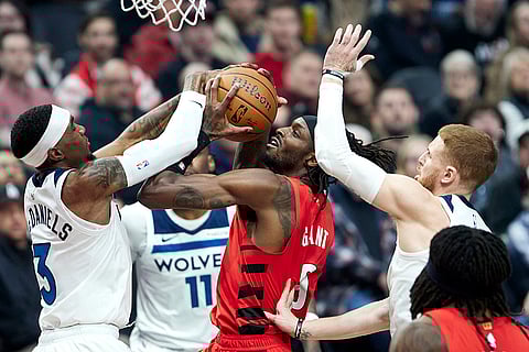 NBA Cup: Trail Blazers forward Jerami Grant, center, drives to the basket between Timberwolves forward Jaden McDaniels, left, and guard Donte DiVincenzo