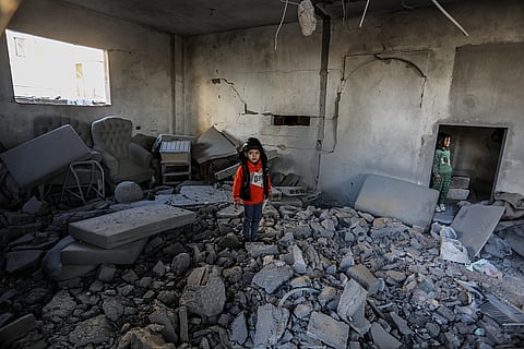 A Palestinian boy stands among rubble in the room of targeted building hit by Israeli army