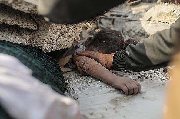 OCTOBER 09: (EDITOR'S NOTE: Image depicts death) A rescuer pulls out the dead body of a little girl from the rubble after Israeli airstrikes in Gaza City, Gaza on October 09, 2023
