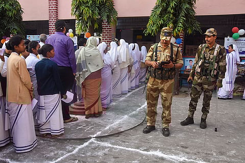 J'khand polls: Security personnel keep vigil as voters stand in a queue