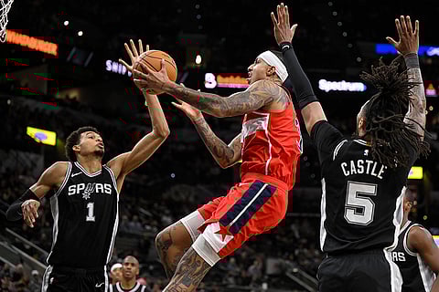 NBA: Wizards' Kyle Kuzma, center, goes to the basket against Spurs' Victor Wembanyama (1)