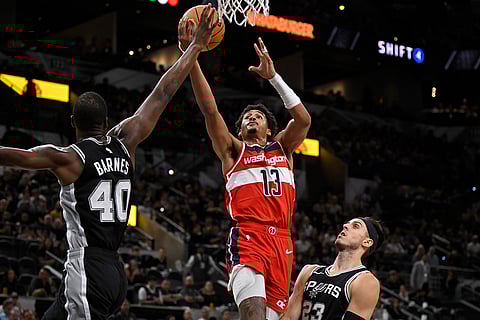 NBA: Wizards' Jordan Poole (13) goes to the basket against Spurs' Harrison Barnes (40) and Zach Collins
