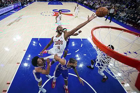 NBA: Cavaliers' Evan Mobley, center, reaches for a rebound against 76ers' Jared McCain