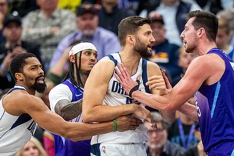 NBA Mavericks vs Jazz Basketball: Mavericks forward Naji Marshall, left, and Jazz guard Jordan Clarkson hold Mavericks forward Maxi Kleber