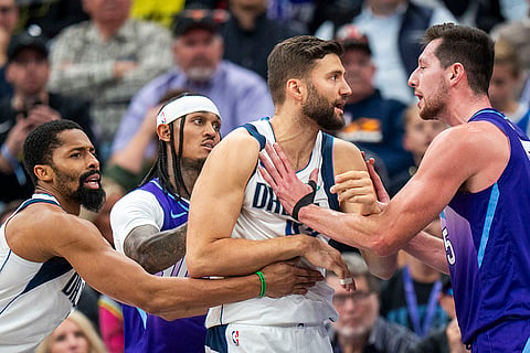 NBA Mavericks vs Jazz Basketball: Mavericks forward Naji Marshall, left, and Jazz guard Jordan Clarkson hold Mavericks forward Maxi Kleber