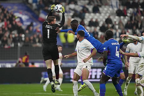 UEFA Nations League soccer: Israel's goalkeeper Daniel Peretz, left, and France's Ibrahima Konate, centre top, challenge for the ball