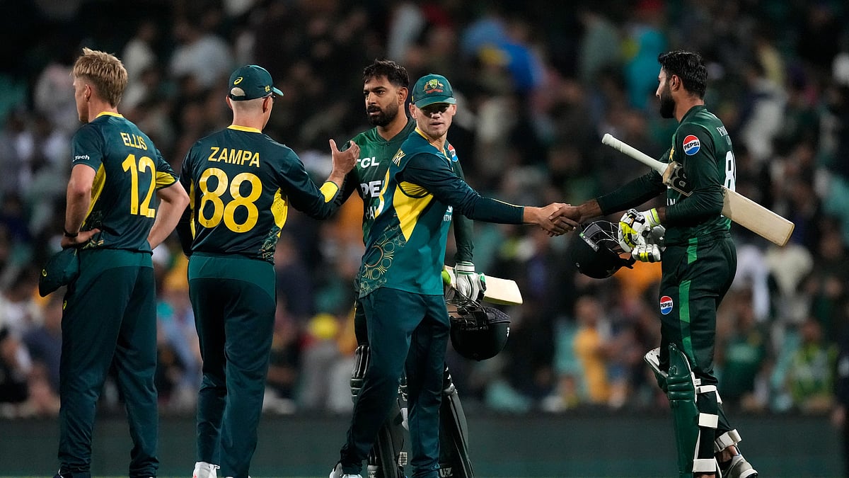 AP Photo/Rick Rycroft : Australia's Jake Fraser-McGurk shakes hands with Pakistan's Irfan Khan, right, after Australia won the T20 international cricket match against Pakistan in Sydney.