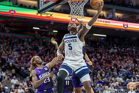 NBA: Timberwolves guard Anthony Edwards (5) makes a reverse layup past Kings forward Trey Lyles