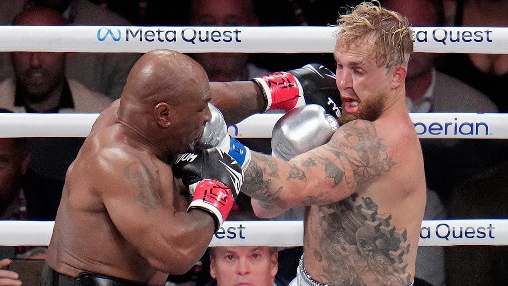 Photo: AP/Julio Cortez : Mike Tyson punches Jake Paul during their heavyweight boxing match in Arlington, Texas.