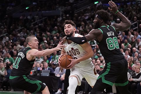 NBA Basketball: Cavaliers guard Ty Jerome, center, tries to drive between Celtics guard Payton Pritchard (11) and center Neemias Queta