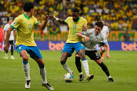 Football World Cup 2026 Qualifiers: Brazil's Gerson, center, and Uruguay's Facundo Pellistri battle for the ball