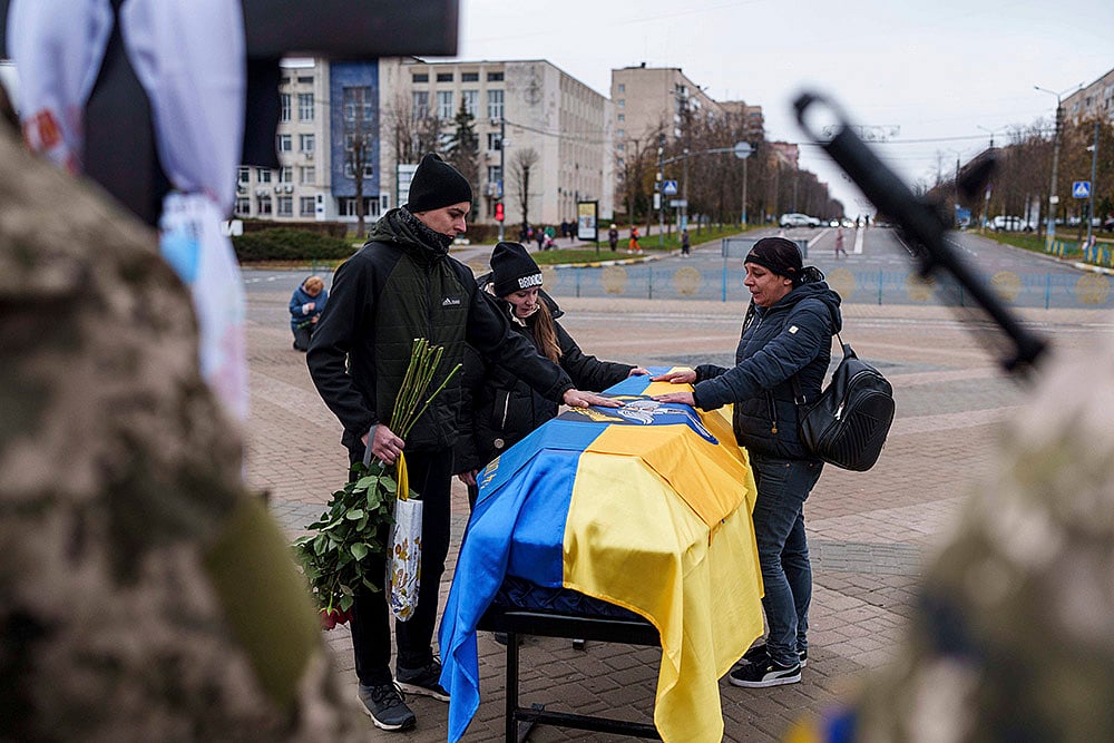 | Photo: Photo/Evgeniy Maloletka : Russia Ukraine War 1000 Days: Olena Moiseeva with her son and daughter cry near the coffin of her husband Yurii Moiseev