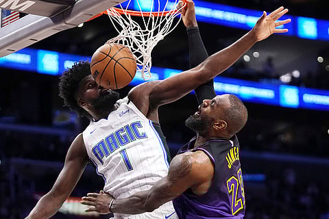 NBA: Lakers forward LeBron James, right, dunks in the face of Magic forward Jonathan Isaac