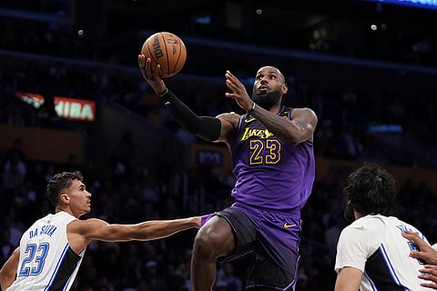 NBA: Lakers forward LeBron James, center, shoots as Magic forward Tristan da Silva, left and center Goga Bitadze defend