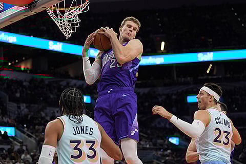 NBA: Jazz forward Lauri Markkanen (23) grabs a rebound over Spurs guard Tre Jones (33) and forward Zach Collins (23)