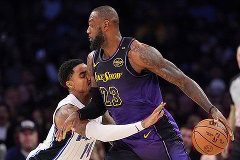 NBA: Magic guard Gary Harris, left, reaches in on  Lakers forward LeBron James