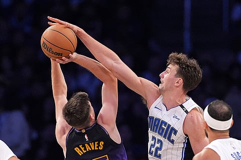 NBA: Lakers guard Austin Reaves, left, shoots as Magic forward Franz Wagner defends