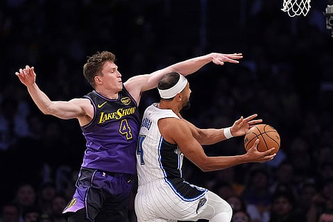 NBA: Magic guard Jalen Suggs, right, shoots as Lakers guard Dalton Knecht