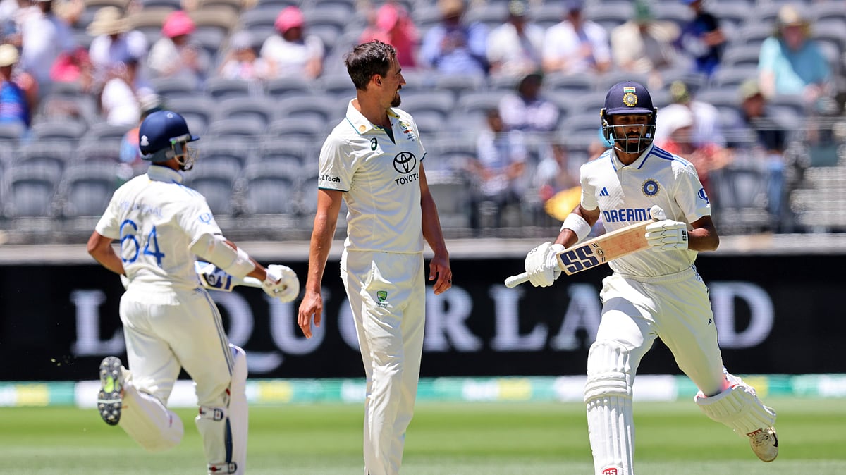 AP Photo/Trevor Collens : Australia's Mitchell Starc, centre, watches as India's Devdutt Padikkal, right, and Yashasvi Jaiswal run between the wickets on the third day of the first cricket test between Australia and India in Perth.